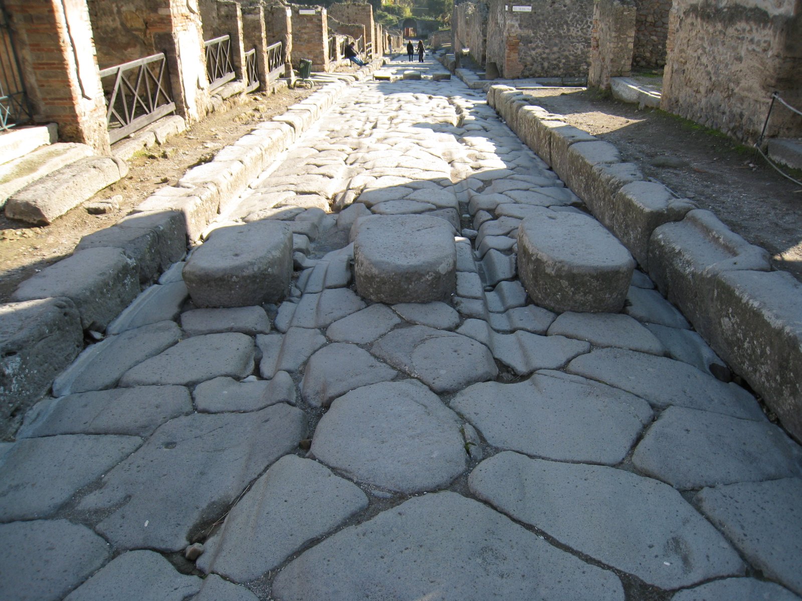 Calle de Pompeya con piedras de paso elevadas y rodadas de ruedas de carreta a los lados