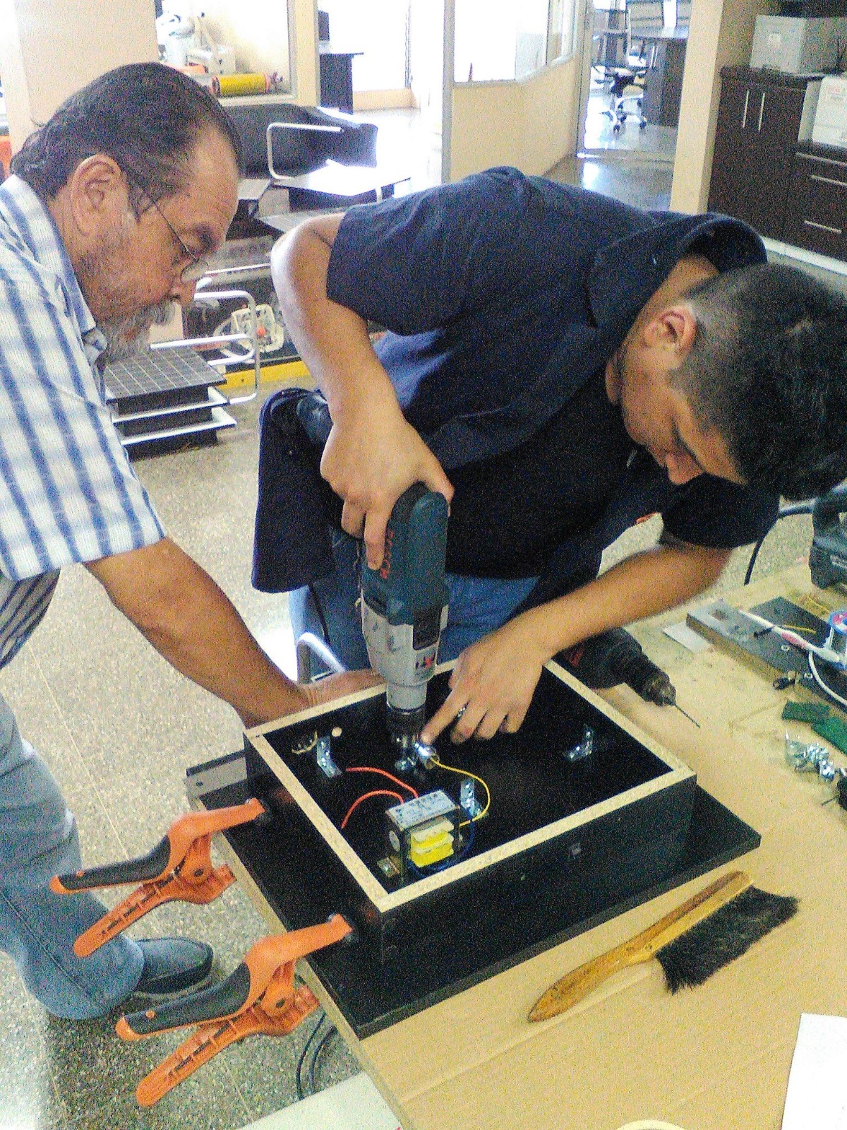 Don Salvador Mux ensamblando un prototipo electrónico